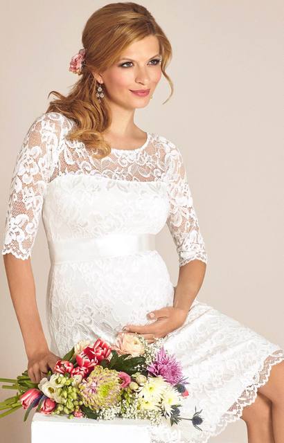 Gravid brud i kort blondebrudekjole med buket