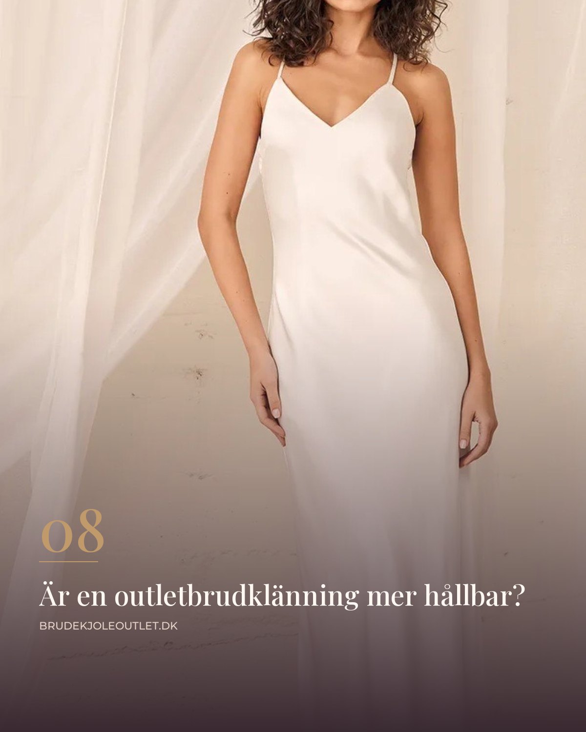 Enkel brudklänning i slipmodell med smala axelband i blankt tyg mot ljus vägg